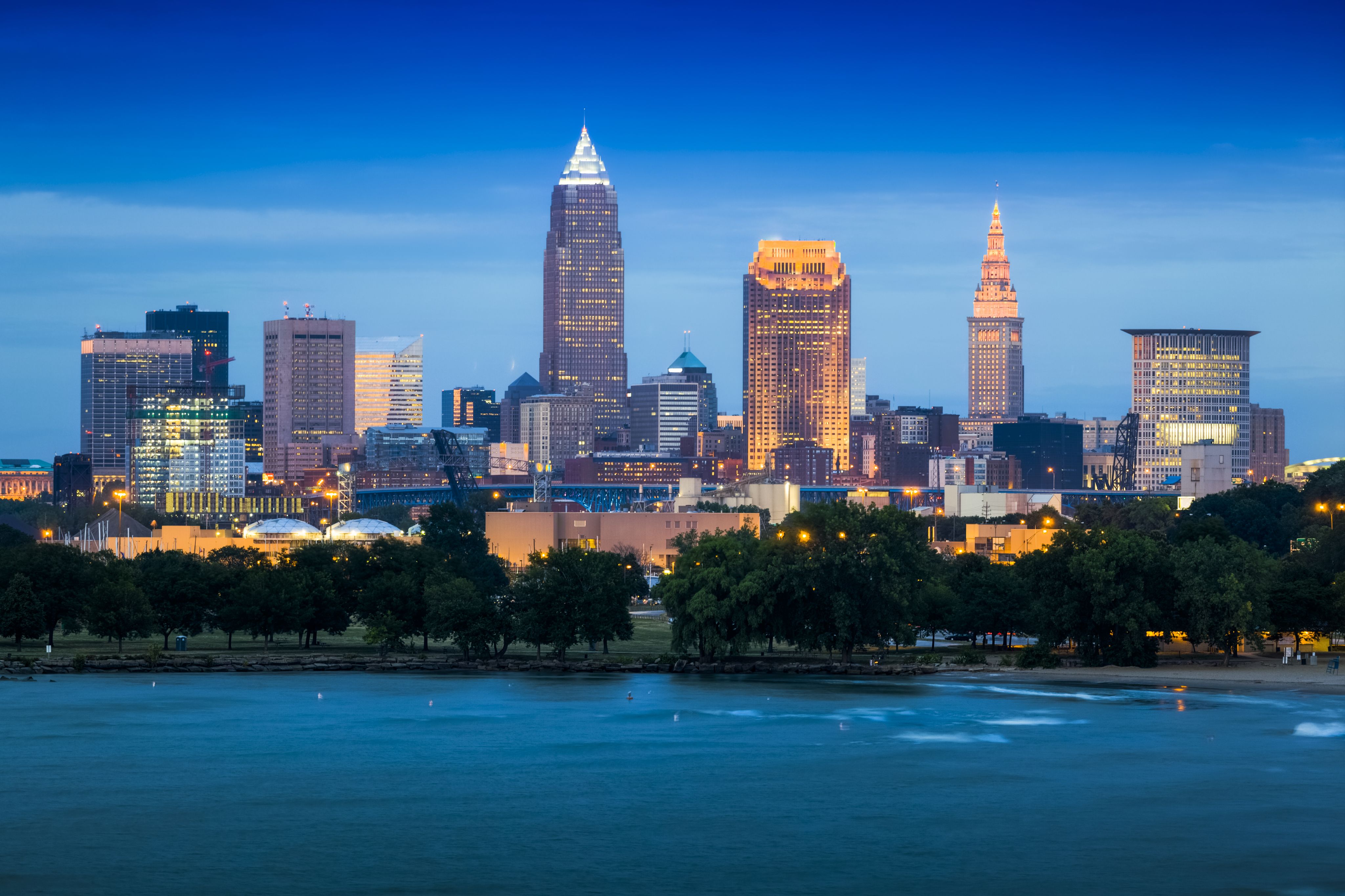 Cleveland skyline, looking across the river to a park with some trees and then a collection of tall buildings in the background
